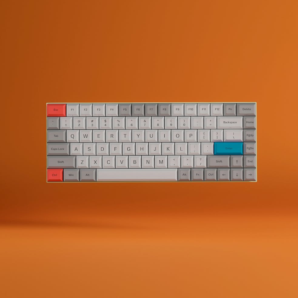 A modern mechanical keyboard with colorful keys against an orange backdrop.